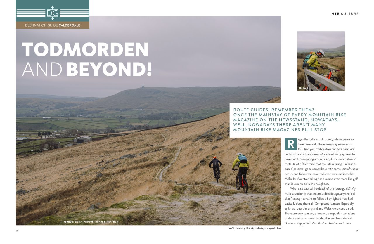 Scenic landscape view of Todmorden with two mountain bikers riding on a rocky trail surrounded by grassy hills and distant valleys under a cloudy sky.