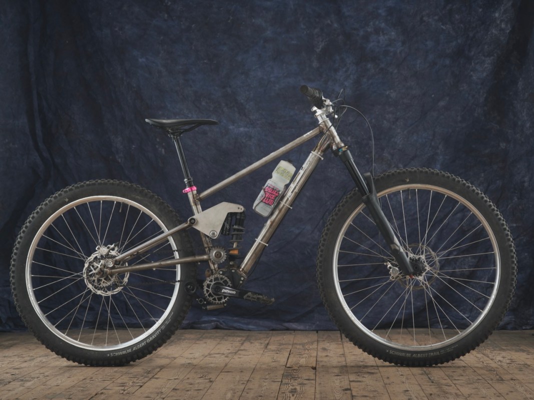 A custom-built full suspension bike with a pinion gearbox and adjustable suspension, showcasing distinct geometry and unique design features.
