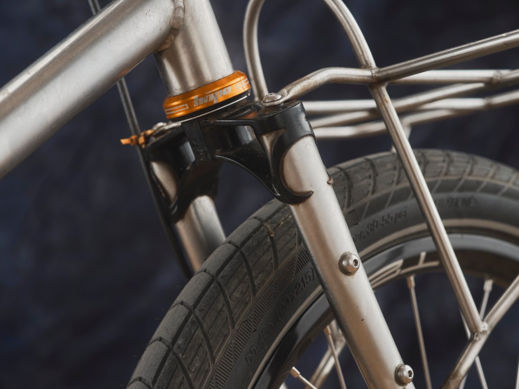 Close-up of a mountain bike's front suspension and wheel, showcasing the adjustable components and sleek aluminum frame.