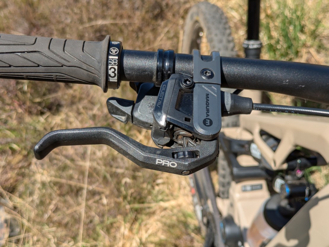 Close-up of the handlebar controls on a Moustache Clutch eMTB, featuring the Magura brake lever and gear shifting mechanism.