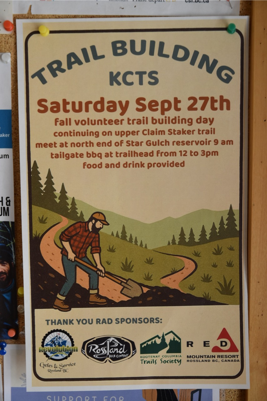 A poster announcing a volunteer trail building day organized by the Kootenay Columbia Trails Society, featuring an illustration of a man digging on a trail with trees in the background. Includes event details such as date, location, and sponsors.