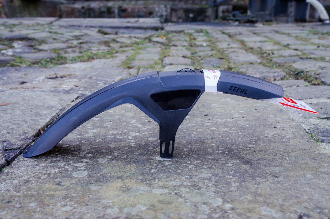 Side view of a Zefal FM40 front mudguard on a stone surface with packaging still attached.