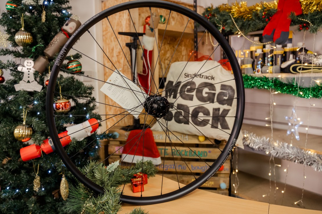 A HUNT Trail Wide wheelset displayed prominently on a table, decorated with Christmas ornaments and lights in the background, showcasing a festive setting.