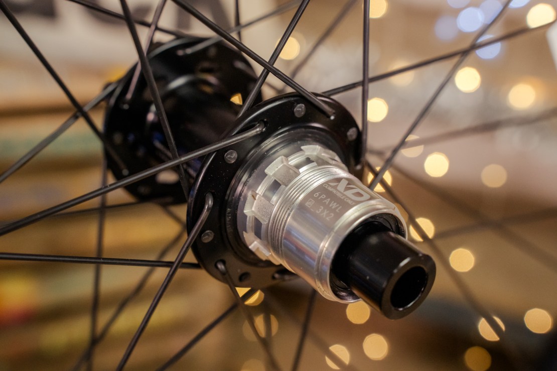 Close-up of a bicycle wheel hub showcasing the XD driver body and spokes against a blurred background with soft lighting.
