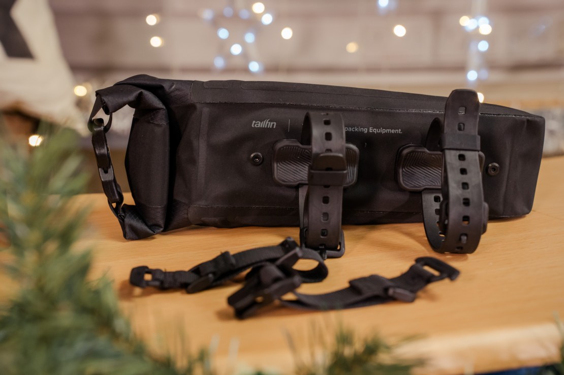 A black waterproof bag designed for outdoor equipment, featuring adjustable straps and a sturdy base.