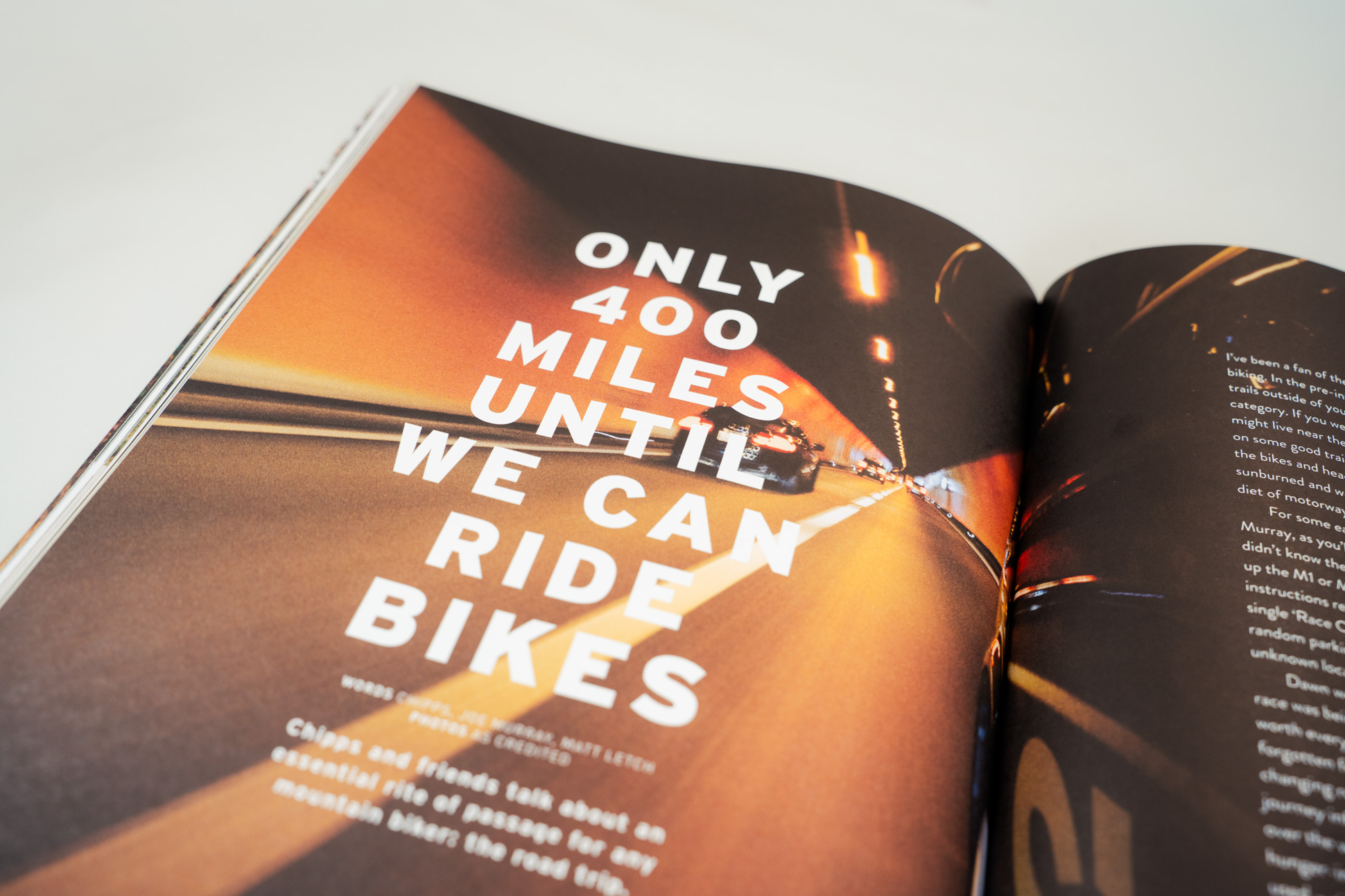 A magazine page featuring bold text that reads 'ONLY 400 MILES UNTIL WE CAN RIDE BIKES', with a blurred image of a vehicle driving through a tunnel.