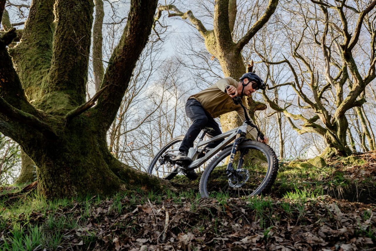Orange Stage 6 mountain bike on a trail, side profile showing full 150mm travel 29er frame