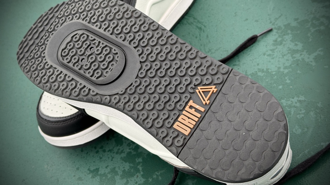 Close-up of the sole of a Drift shoe, featuring a textured black rubber design with an orange Drift logo. Drift ARC