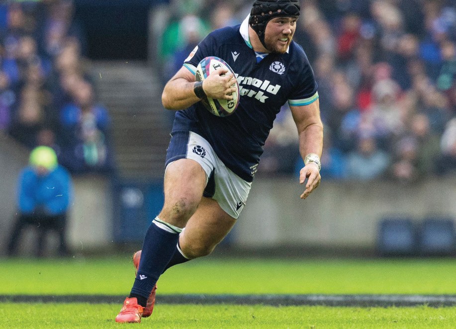 Zander Fagerson running with the ball during a Scotland rugby match.