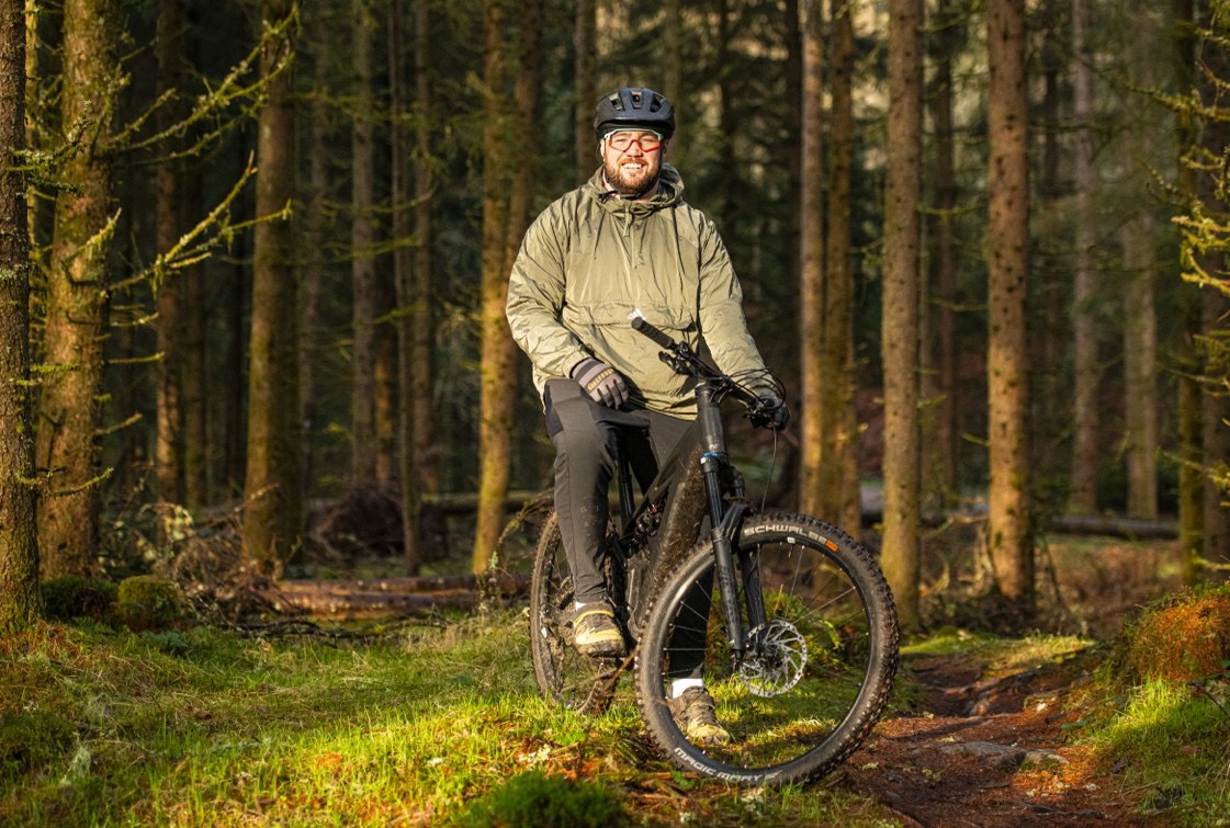 A rider on singletrack through a pine forest.