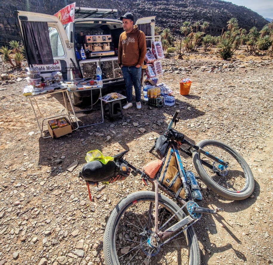 A loaded singlespeed bike lying beside a roadside stall in Morocco.