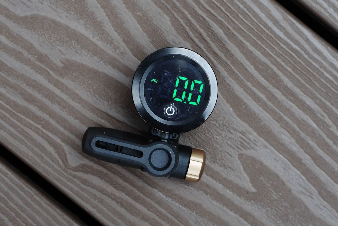 Digital tyre pressure gauge displaying 0.00 PSI on a wooden surface.