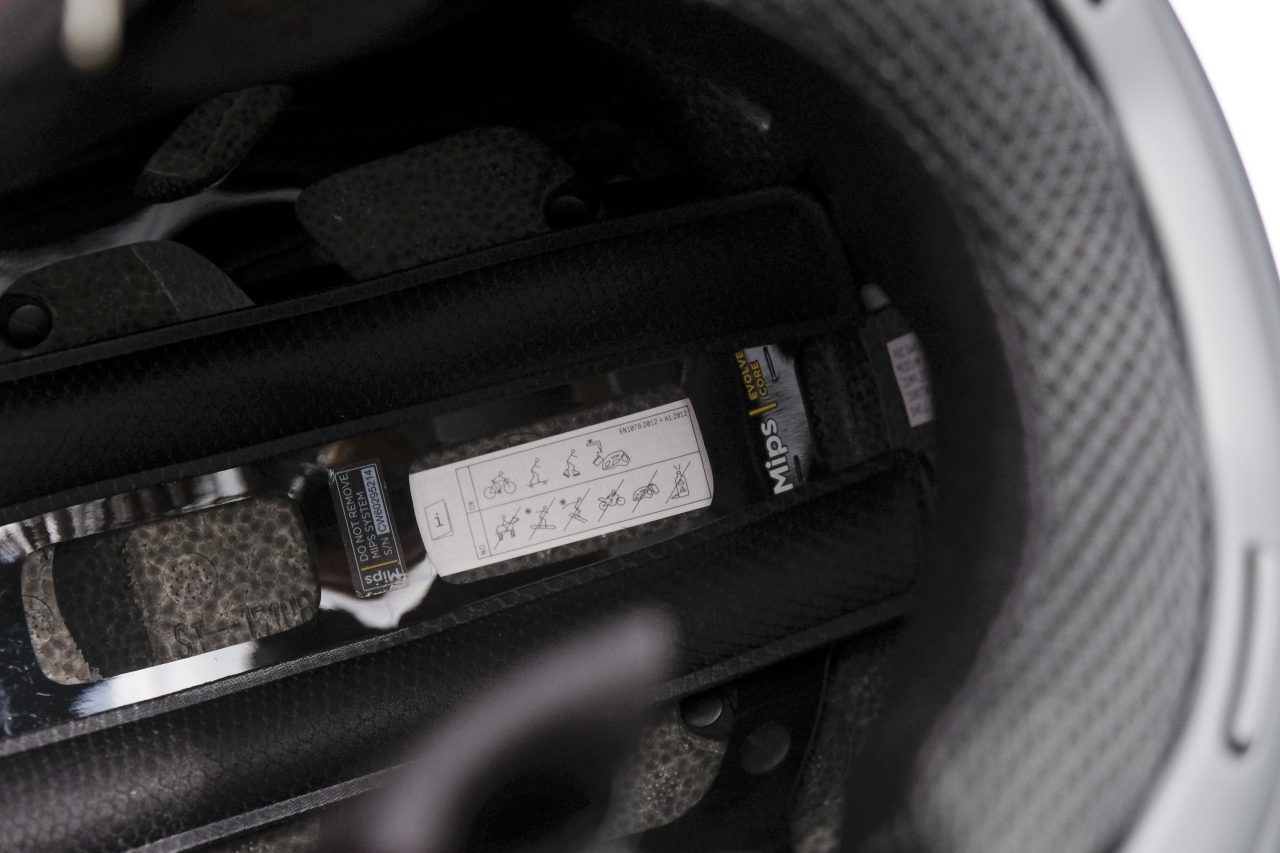 Interior view of a cycling helmet showing MIPS technology and safety instructions.