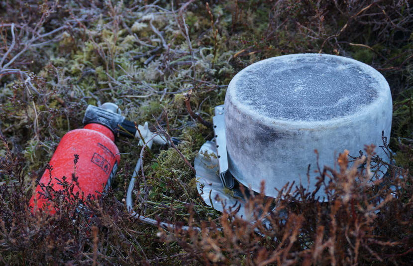 A fat bike dusted with frost like caster sugar in the still, early morning light at camp