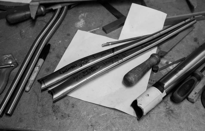 The Downland Cycles workshop bench laid out with tubes, tools and a frame in progress