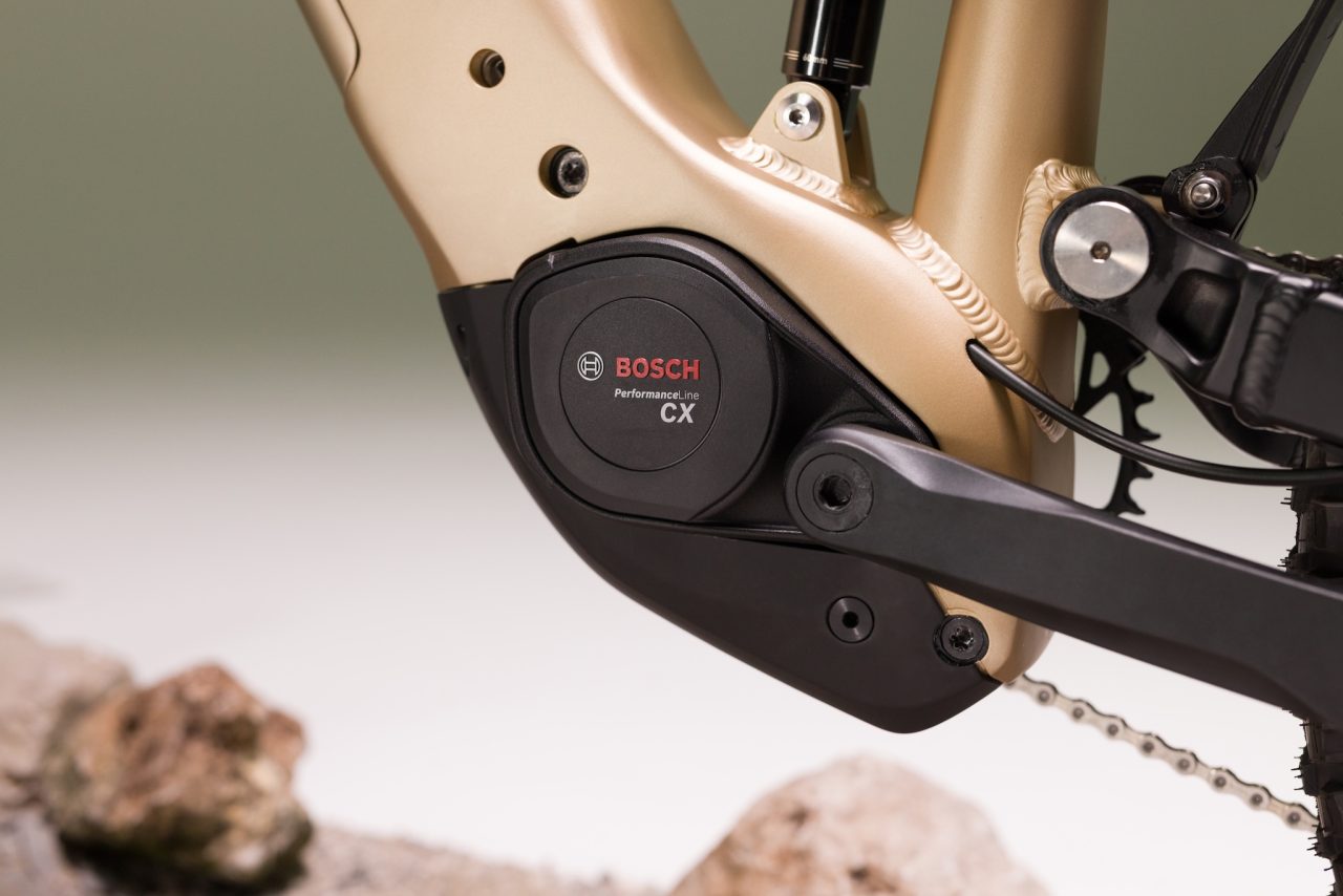 Close-up view of a Bosch Performance Line CX motor mounted on a bike frame, showcasing the sleek black and gold design.